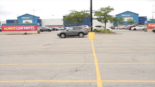 ウォルマートのスーパーセンターストアスーパーマーケットデパートブルー ウォルマートの前でバックグラウンドで車両が通過する前にサインロゴと駐車場 ワイドショット — ストック動画