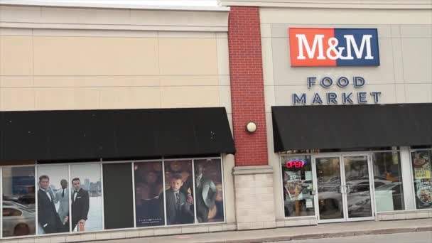 MおよびMのネオン オープン サインが付いている店の外部の印のロゴが付いている食品市場の前部入口 オレンジ ブルーの白 — ストック動画
