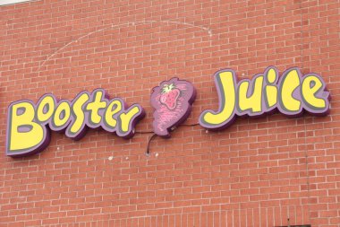 Tuğla duvarda sarı, mor ve kırmızı logo işareti var. Kapatın.