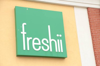 Freshii restoranının logosu, duvarda beyaz çerçeveli yeşil kare yazılar var. Kapatın.