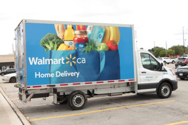 Walmart eve teslim küçük bir kamyon park yerinde park halinde sebze ve meyve mavisi resimli.