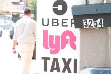 Uber lyft taksi dikey tabela logoları Aydınlık bir günde posta kutusu ve yol caddesinde mesaj yazarken arkasında yürüyen biri var