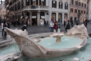 Avlu meydanı, İspanyol basamaklarının yanında Roma çeşmesi ve gün boyunca yürüyen yayalar.