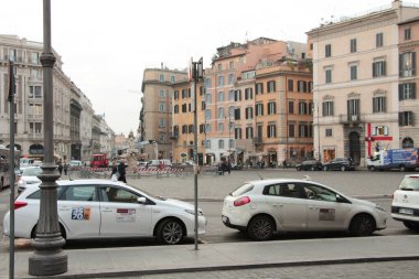 Piazza di Barberini genişliğinde, kavşakta çeşme var. Döner kavşak, döner kavşak, araba trafiği, park halindeki insanlar ve Roma 'daki şehir merkezindeki insanlar.