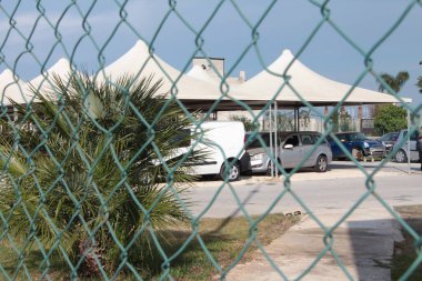 Pachino Sicilya 'da açık bir günde yeşil çitlerden beyaz çadırlardan, tentelerden ve altında arabalar park edilmiş arabalardan geçer.