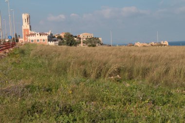 Portopalo Sicilya kırmızısı beyaz kale okyanus suyunun yanından gökyüzü bulutlu, geniş açılı üst çerçeve