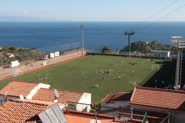 Taormina Sicilya İtalya futbol sahasının yanındaki okyanus kıyısındaki kayalıklarda takım atletlerinin evlerle oynadığı bir futbol sahası.