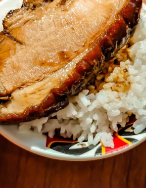 İnce soya soslu domuz eti ve kase içinde beyaz pirinç.