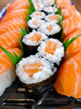 Hosomaki suşisinin yakın plan görüntüsü. Tipik bir Japon yemeği. Pirinç ve somon dilimleriyle dolu yosun.