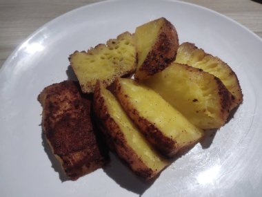 Tarçınlı ızgara ananas dilimleri tatlı olarak beyaz tabakta. Yemek menüsü fotoğrafları için kullanılabilir.