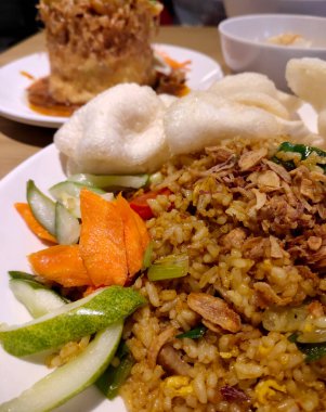 Havuç dilimleri ve salatalık dilimleri ile kaplanmış tipik Endonezya kızarmış pirincine yakından bakın. Derin alan seçici odaklanma. Yemek menüsü fotoğrafları için kullanılabilir.