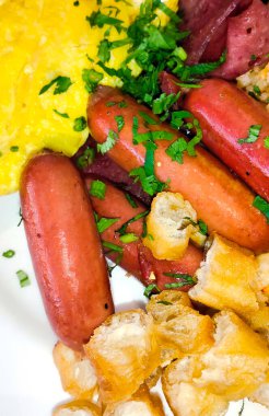 İçinde sığır eti sosisi, tavuk sosisi, omlet ve char kway parçaları olan bir tabak.