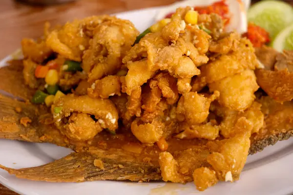 stock image Fried flour gourami fish fillet served on a white plate, close up view, Shallow depth of field composition.