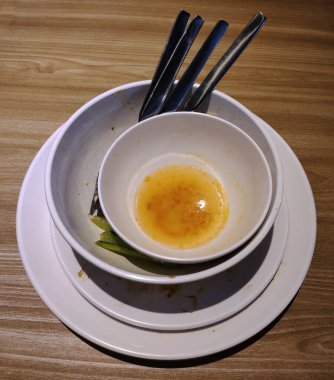 Arta kalan tabakları, kâseleri ve kaşıkları yemek artıklarıyla birlikte istifleyin ki kolayca toparlanabilsinler. Kahverengi masada yedikten sonra