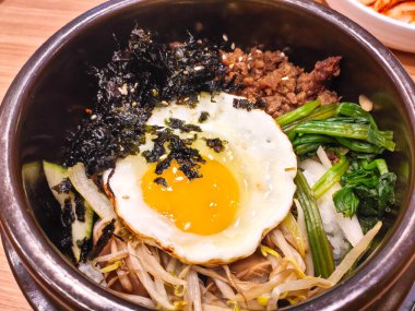 Bibimbap adlı Kore yemeği karışık pirinçtir. Yumurta, sığır eti, sebze ve deniz yosunlarıyla doludur..