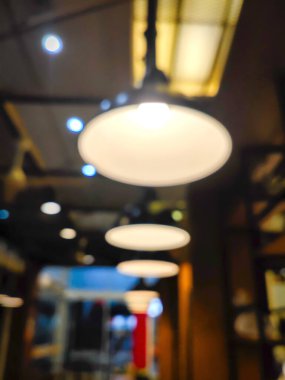 Kahve dükkanının atmosferinde asılı lambaların bulanık fotoğrafı.