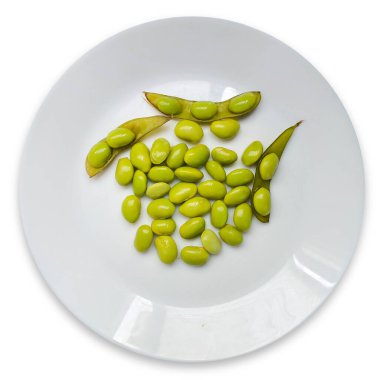 Edamame kapsülleri fasulyelerle haşlanarak pişirilir ve beyaz bir tabakta servis edilir..