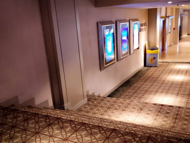 Jakarta, Endonezya - 30 Aralık 2024: Boş bir sinema koridoru desenli halı ve film afiş kutularıyla döşenmiştir. Arkaplan ya da eğlence için mükemmel. 