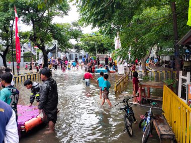 Jakarta, Endonezya - 29 Ocak 2025: Çocuklu insanlar Taman Palem Cengkareng, Jakarta - Endonezya 'daki Şehir Parkı' ndaki sel baskınlarında oynamaktan çok mutlular.