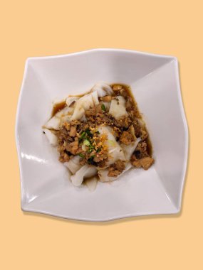 Pirinçli erişte rulosu, ya da soya soslu domuz dilimli cheung fun olarak da bilinir. Krema arkaplanlı beyaz bir tabakta servis edilir..