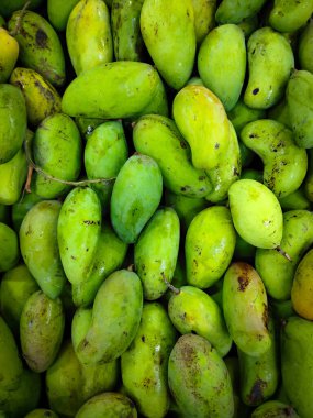 Bir yığın taze yeşil mango meyve pazarında satılık bir çerçeve dolduruyor..
