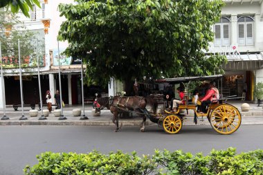 Endonezya 'da ünlü bir turizm merkezi olan Malioboro caddesindeki yolcularla dolu at arabası.