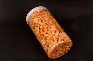 Siyah arka planda bir kavanoz makarna.