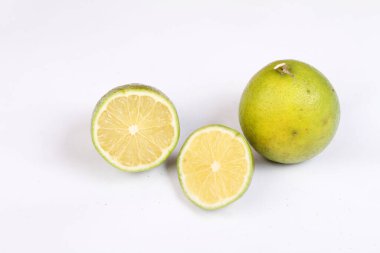 Beyaz zemin üzerinde taze olgun ve yeşil limonlar