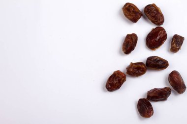 Beyaz arka planda tahta kaşıkla kurutulmuş tarihler