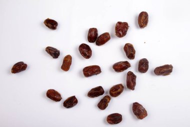 Beyaz arka planda tahta kaşıkla kurutulmuş tarihler