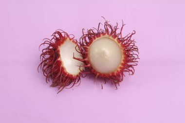  Pembe arka planda bir rambütan.