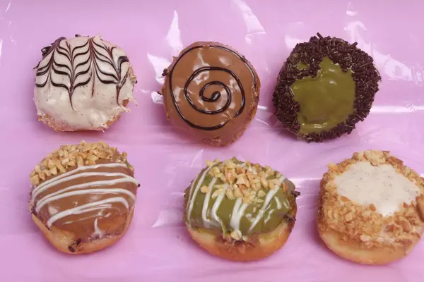 Uma Bandeja Rosa Com Seis Donuts Diferentes — Fotografia de Stock