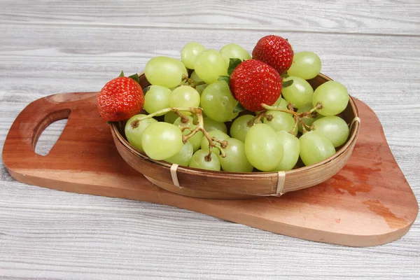 Frische Grüne Trauben Und Erdbeeren Auf Holzteller — Stockfoto