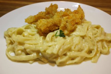 Bir tabak kızarmış tavuklu makarna.