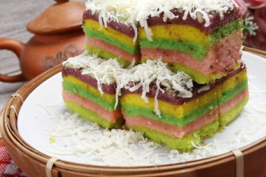 Tabağında rendelenmiş peynir olan gökkuşağı pastası