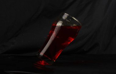 Siyah arkaplanlı bir bardakta bir içkinin dikey çekimi.