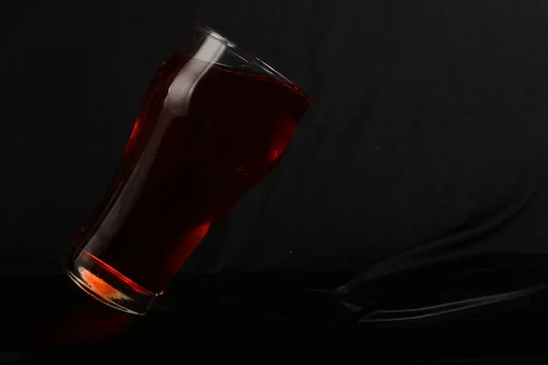 Стакан Красным Напитком Темной Поверхности Напиток Наливается Чёрном Фоне — стоковое фото
