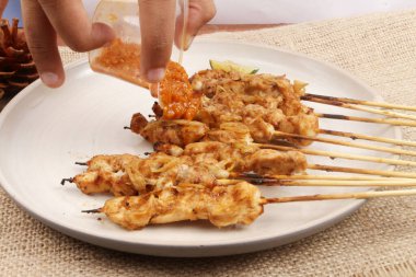 Masada bir tabak tavuklu tai chan satay