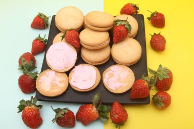 Taze ve lezzetli mini kurabiyeler ve çilekler.