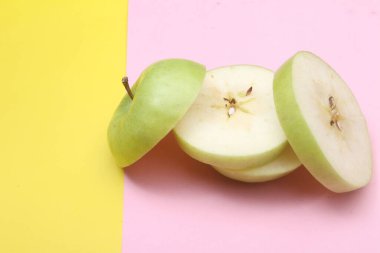 Renkli arkaplanda yeşil elma dilimi