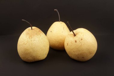 Siyah bir arka planda olgun armutlar