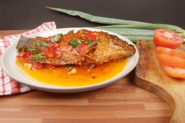 Domatesli balık ve tabakta soğan..