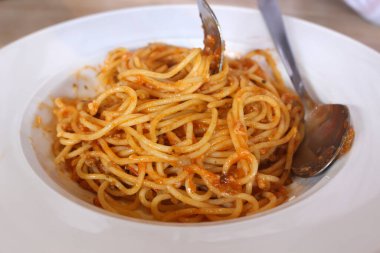 Beyaz tabakta domates soslu spagetti.