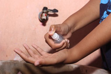 Çocuk ellerini yıkıyor.