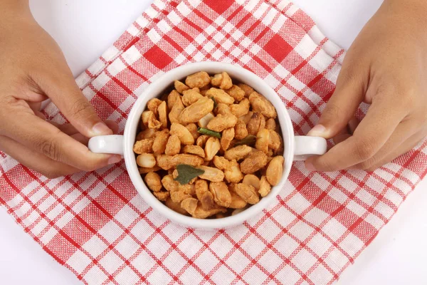 bowl of peanuts with milk in hand, isolated on white background