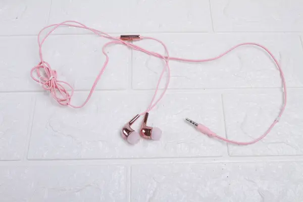 供音乐播放器用的粉色耳机和白色电缆 — 图库照片