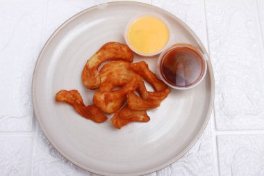 Soslu tavuk nugget ve beyaz tabakta baharat.