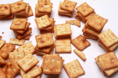 Beyaz arka planda peynirli ve sarımsaklı çıtır krakerler..