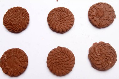 Beyaz arka planda bir sürü çikolatalı kurabiye var.