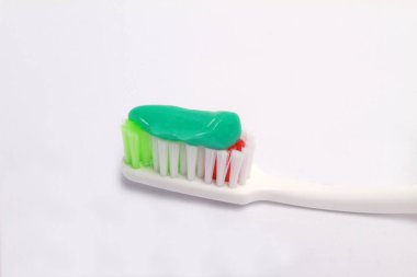 Beyaz arka planda yeşil diş macunu olan diş fırçası. diş bakımı.